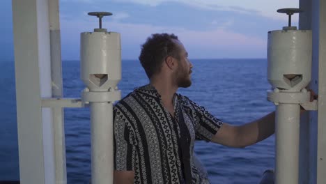 the man looking out to sea from inside the ship.