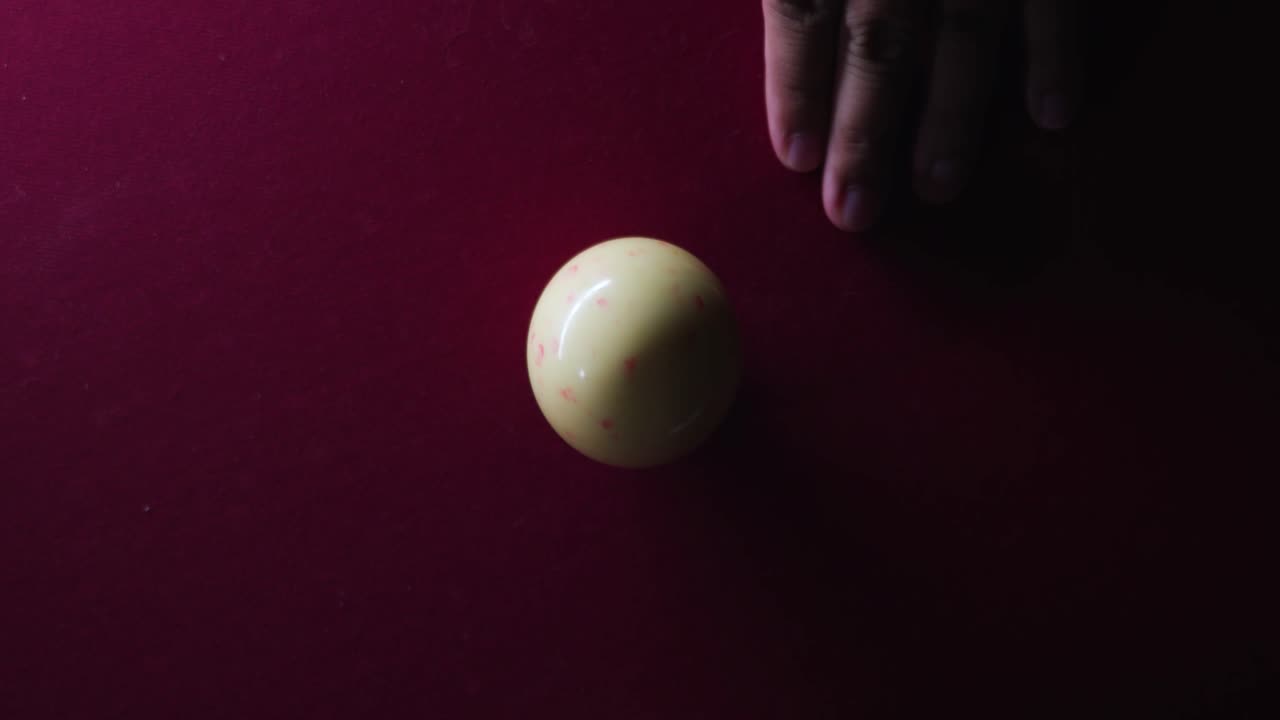 Man hitting cue ball on pool table