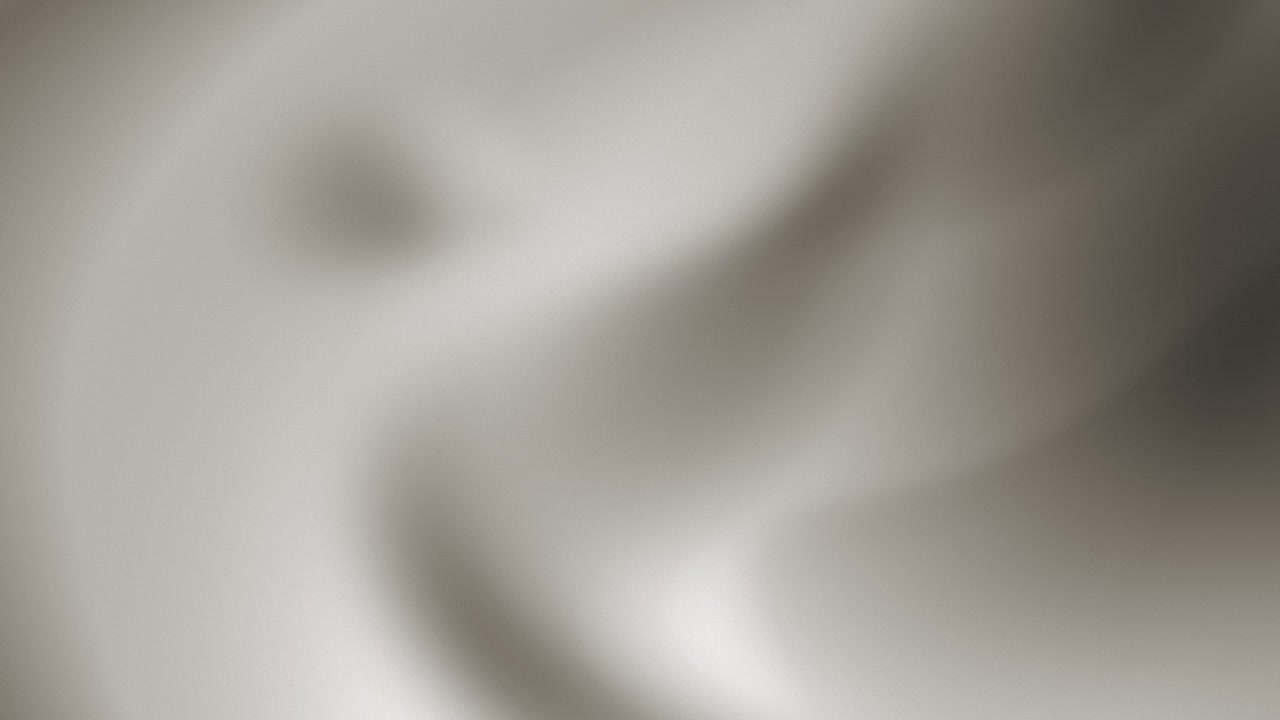 An abstract animation features soft grey fog flowing and moving in slow, fluid waves, revealing blurred, shadowed edges, luminous folds, and subtle tonal gradients while creating a cloud-like texture