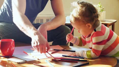 father and his baby son drawing with colored pencils in living room 4k