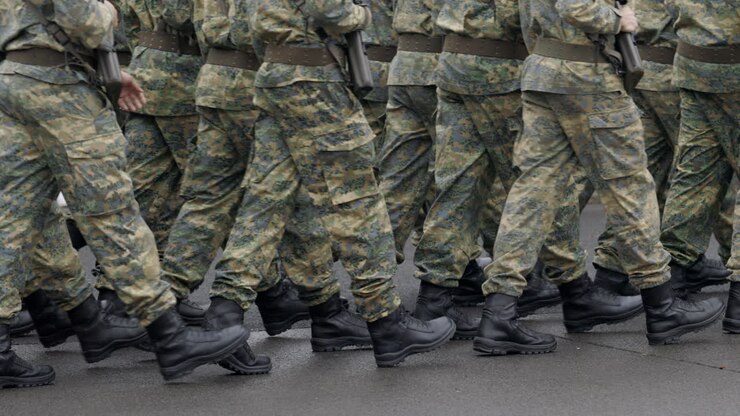 Soldati che marciano in uniforme mimetica