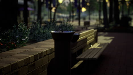 water fountain at sunset in a peaceful park setting with benches