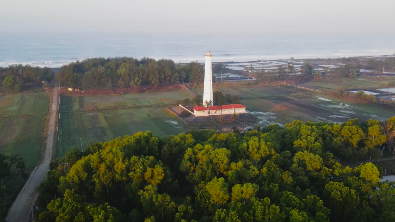 Aerial establisher white lighthouse on the beach of Ketawang in Indonesia