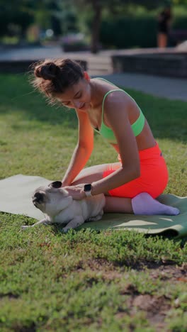 woman exercising with her pug in the park