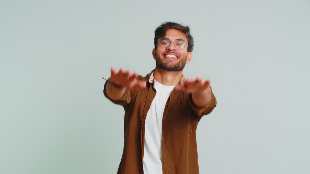 Un giovane indiano felice che ascolta musica, danza, discoteca, si diverte, si rilassa alla festa, fa mosse divertenti.