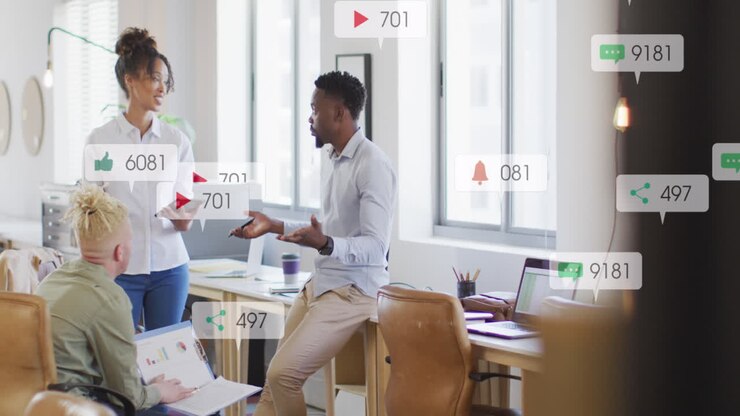 Anmation of social media icons falling against diverse colleagues discussing together at office