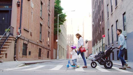 two families with young kids crossing a street in brooklyn