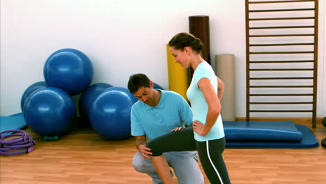 mujer haciendo lunges con su entrenador