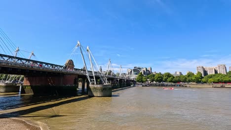 los remeros pasan por debajo de los puentes del jubileo de oro.