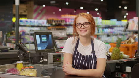 young sales clerk woman smiling and looking at the camera in a supermarket