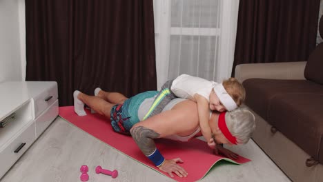 Sportsman-man-working-out-with-child-kid-girl,-push-ups-exercises-with-daughter-lying-on-his-back