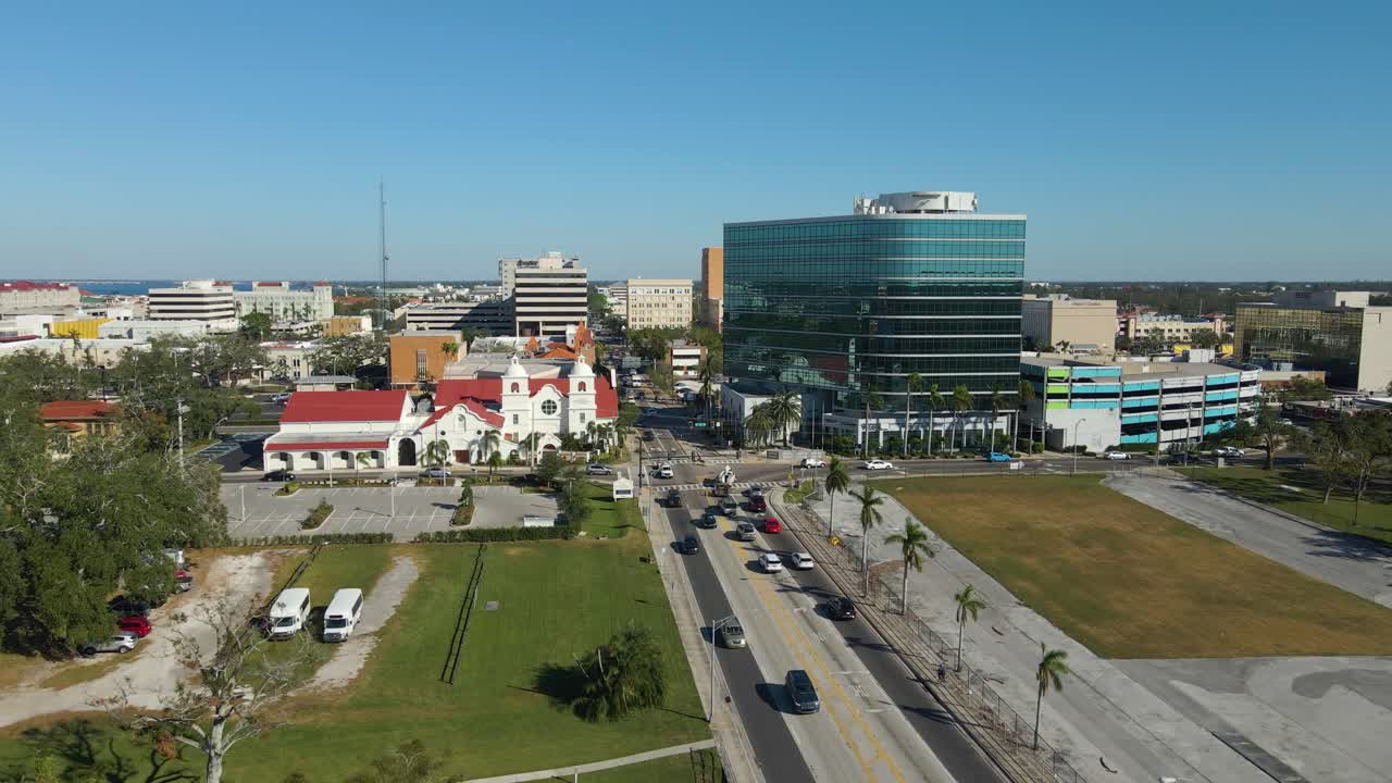 Aerial drone view of downtown Bradenton Florida showcasing buildings, and surrounding cityscape under clear blue skies. Low Dolly Forward E