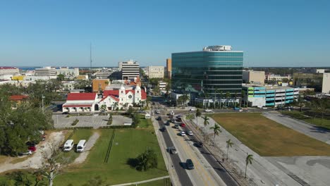 aerial drone view of downtown bradenton florida showcasing buildings, and surrounding cityscape under clear blue skies. low dolly forward e