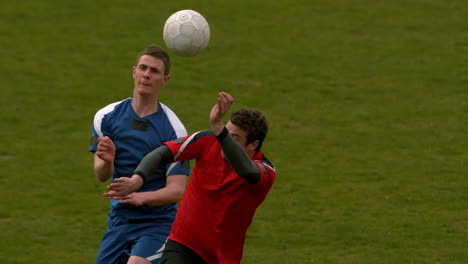 Fußballspieler-Springen-Hoch-Und-Kämpfen-Um-Den-Ball