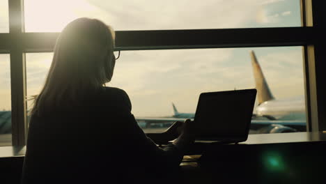 Woman-With-Laptop-Daydreaming-in-Airport