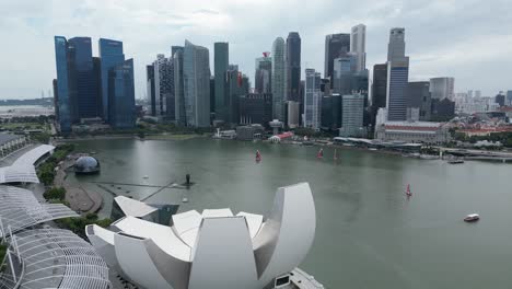 aerial drone shot of art and design building in ultramodern cityscape of singapore, along the marina bay