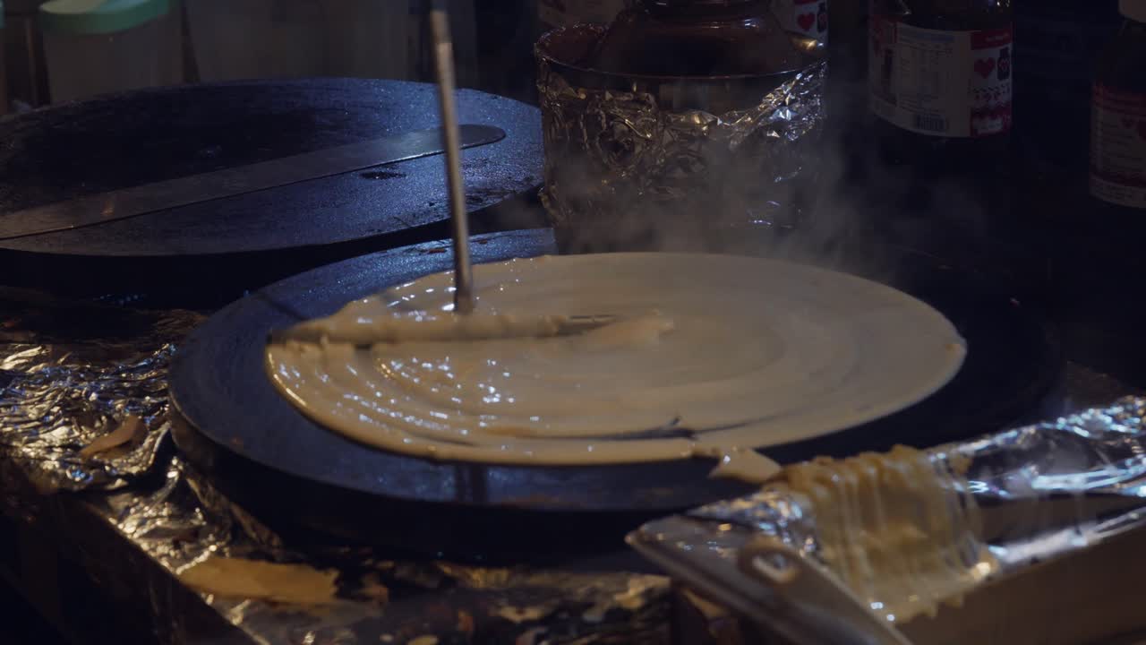 vídeo de un hombre preparando crepes al aire libre en una sartén para crepes de hierro fundido le creuset a la venta
