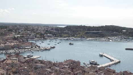 Weite-Luftaufnahme-Der-Schönen-Altstadt-Von-Rovinj-Mit-Hafen,-Gebäuden-Und-Blauem-Wasser-An-Sonnigen-Tagen-In-Kroatien