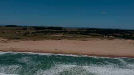 Ola-Oceánica-Natural-Que-Fluye-Por-La-Playa-Oceánica-De-Rocha-Uruguay,-Vegetación-Verde-En-La-Playa-Costera-De-Rocha