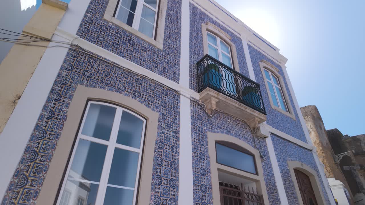 un vibrante edificio de azulejos azules en lagos, portugal, con adornos blancos y un cielo despejado y soleado