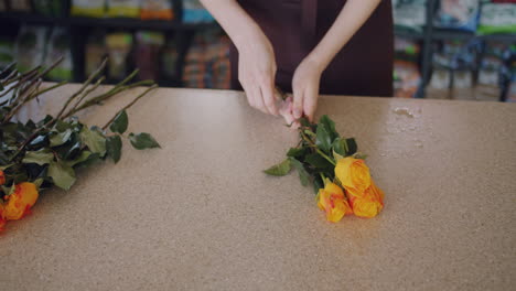 florist arranging orange roses