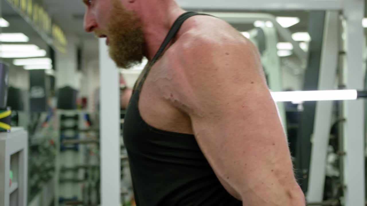 Active bodybuilder young man lifting heavy weights