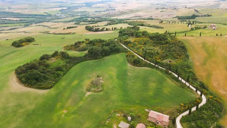 The-road-to-the-little-town-of-Monticchiello-sets-over-the-Val-d'Orcia-in-Tuscany,-Italy