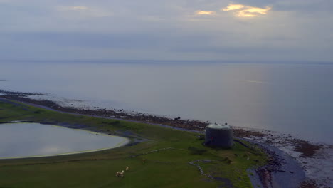 establishing aerial dolly reveals aughinish martello tower and galway bay location