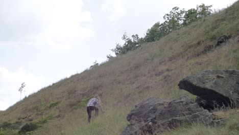 woman climbing hill in rocky rugged moorland wide landscape shot