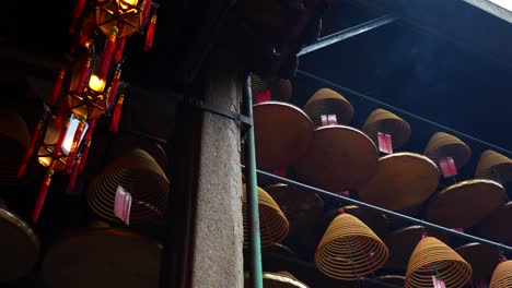 rows of spiral incense sticks hanging in a traditional chinese temple