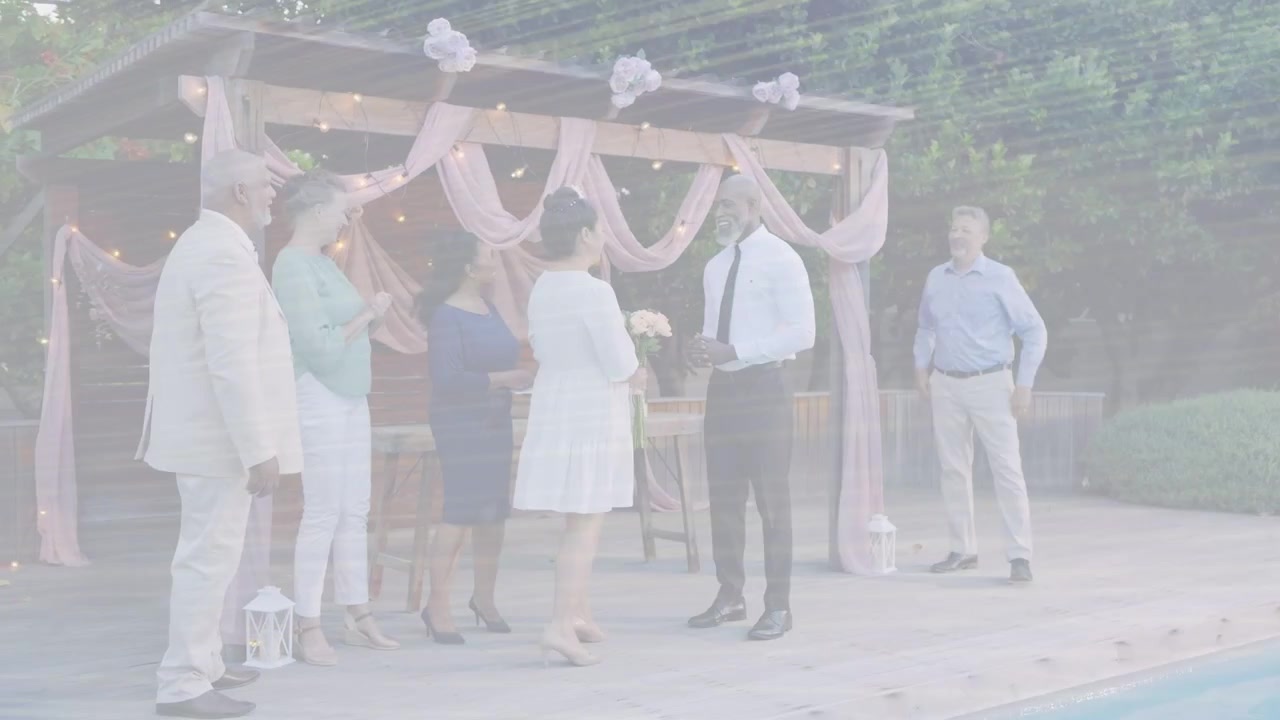Bride approaching wedding pergola, holding bouquet, guests smiling, groom holding ring box for vows