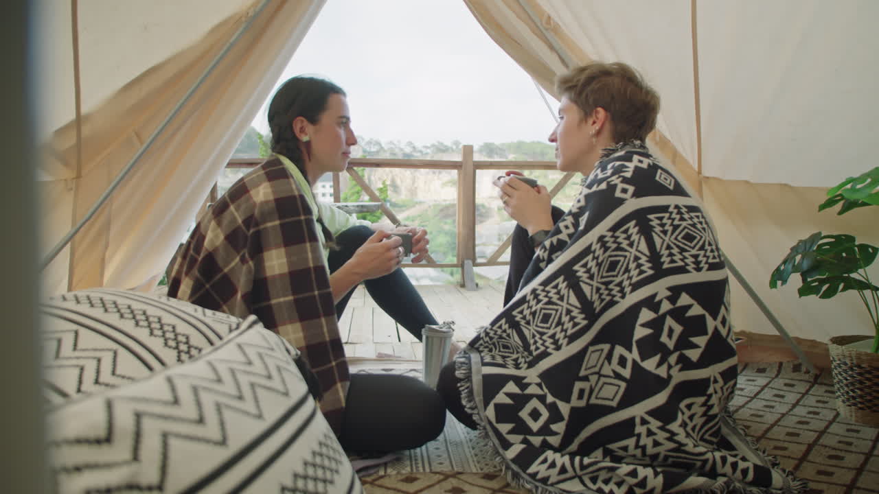 Girls Drinking Tea and Talking in Glamping Tent