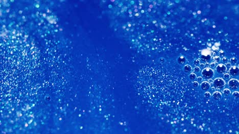 close up view at bubbles and galactic style blue motion of abstract and colorful ink, effervescent circles