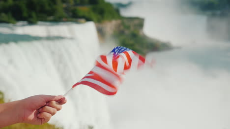 Hand-Mit-Usa-flagge-Auf-Niagara-Fällt-Hintergrund-Reisen-Amerika