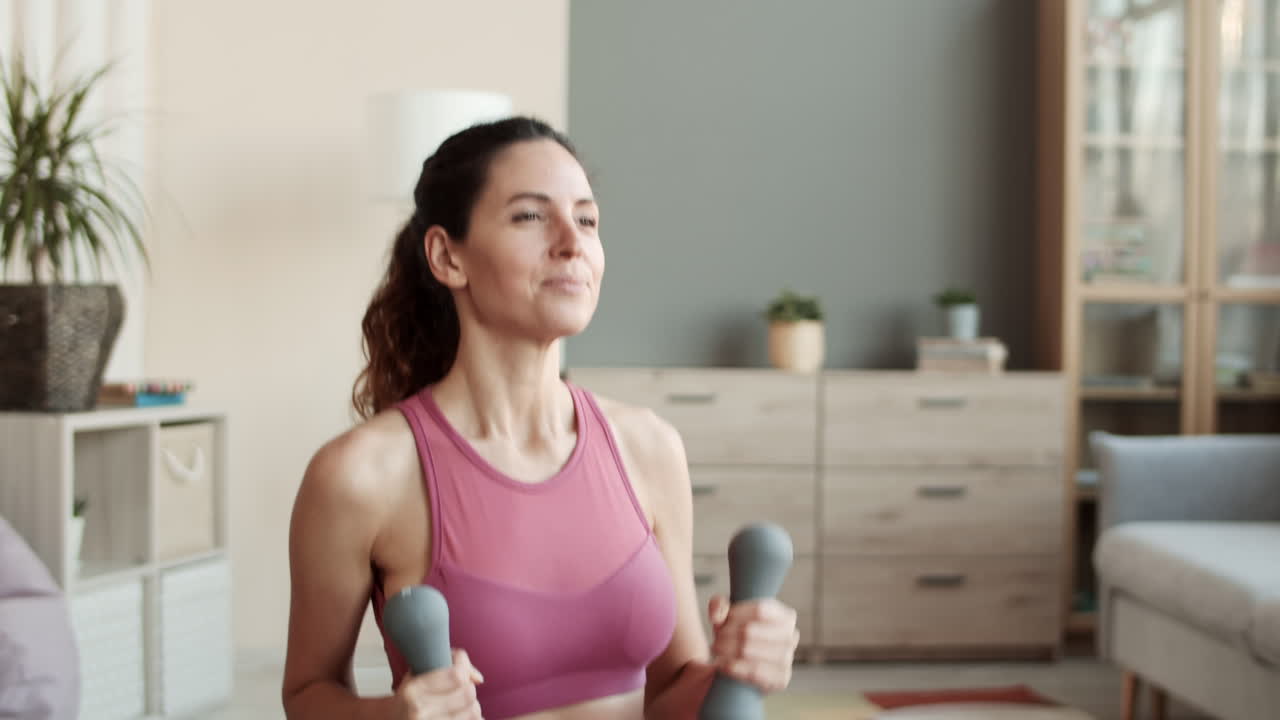 mujer feliz haciendo puñetazos con pesas
