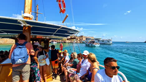 boats taking tourists to spinalonga island to see the ancient, medieval castle fortress off the coast of crete, greece