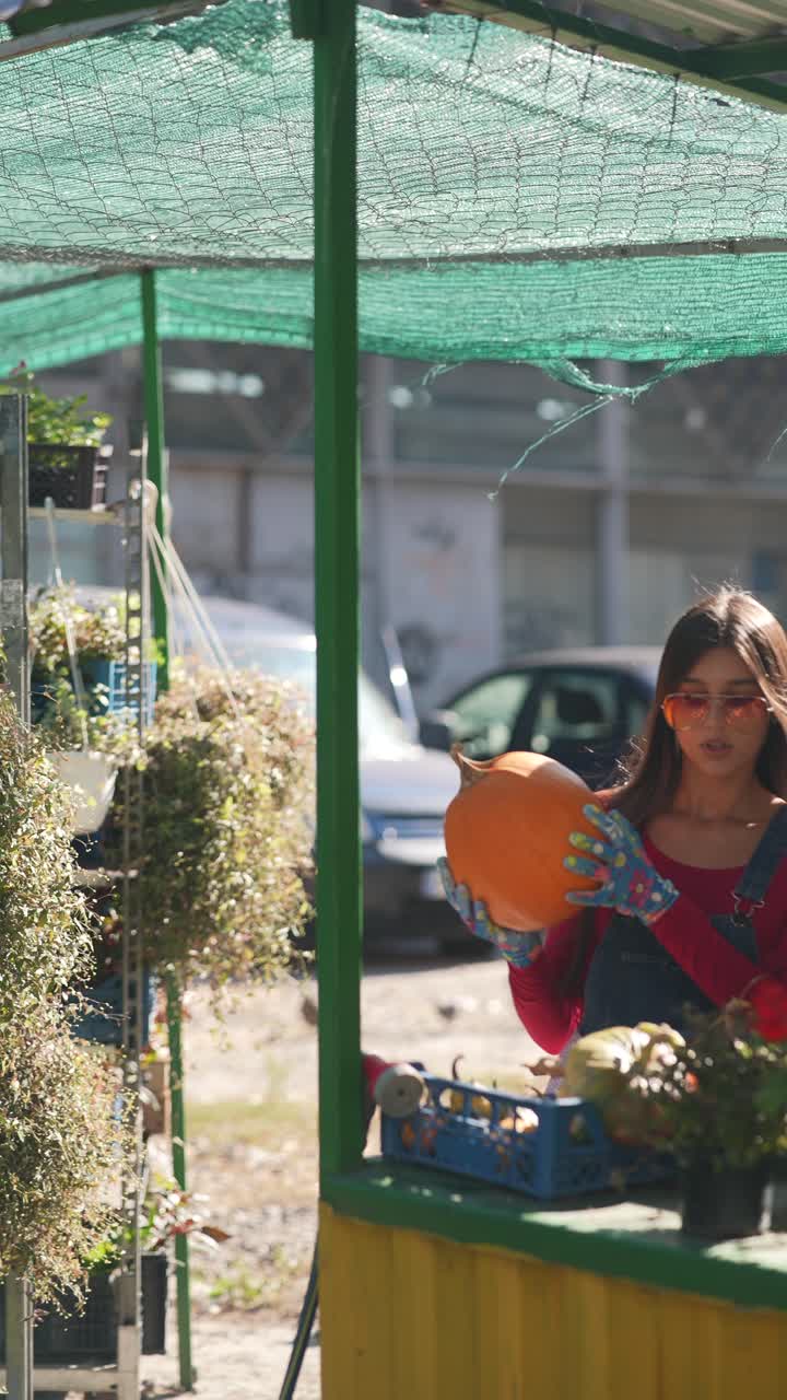 mujer sosteniendo una calabaza en un mercado
