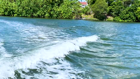 boat wake creates waves in a scenic canal