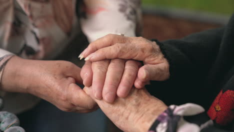 crop senior women holding hands