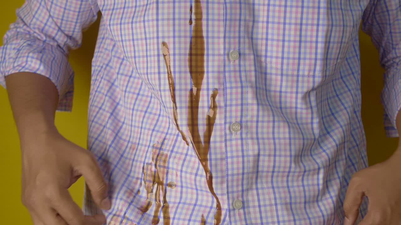 hombre con mancha de café en su camisa