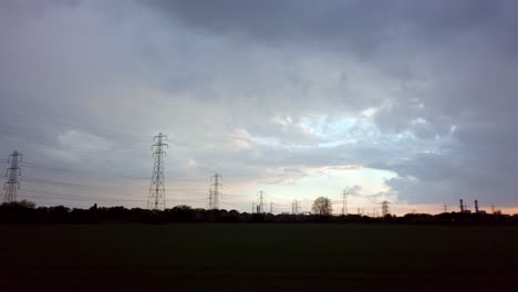 Großbritannien-Sonnenuntergang-Gewitterwolken-über-Feld-Von-Pylonen