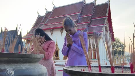 women praying at a temple in thailand