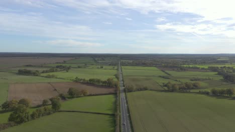 long straight road between countryside field at daytime