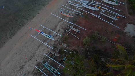 amed playa indonesia con barcos de pesca locales en la orilla durante el amanecer, aérea