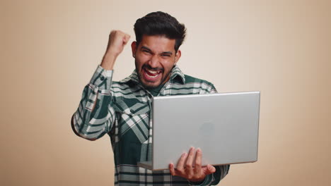 Indian-man-working-on-laptop-project,-enjoying-results,-winning-lottery,-celebrating-success,-winner