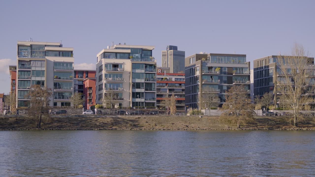 Modern apartment buildings along the river in Frankfurt with a clear sky backdrop