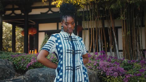 african woman in stylish dress in an asian garden