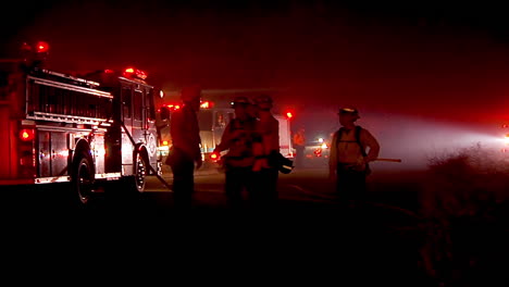 los bomberos discuten la estrategia alrededor de sus camiones durante el incendio festivo en goleta california