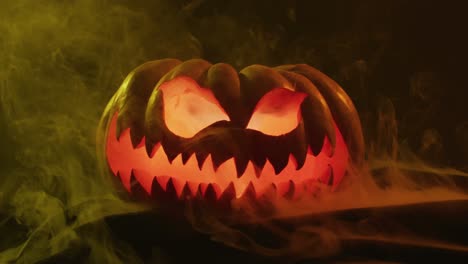 video de calabaza tallada de halloween con humo y luz naranja sobre fondo negro