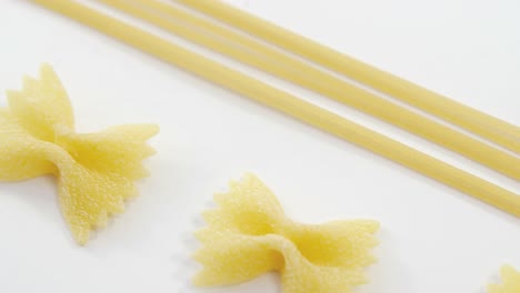 bow tie pasta and spaghetti on white background